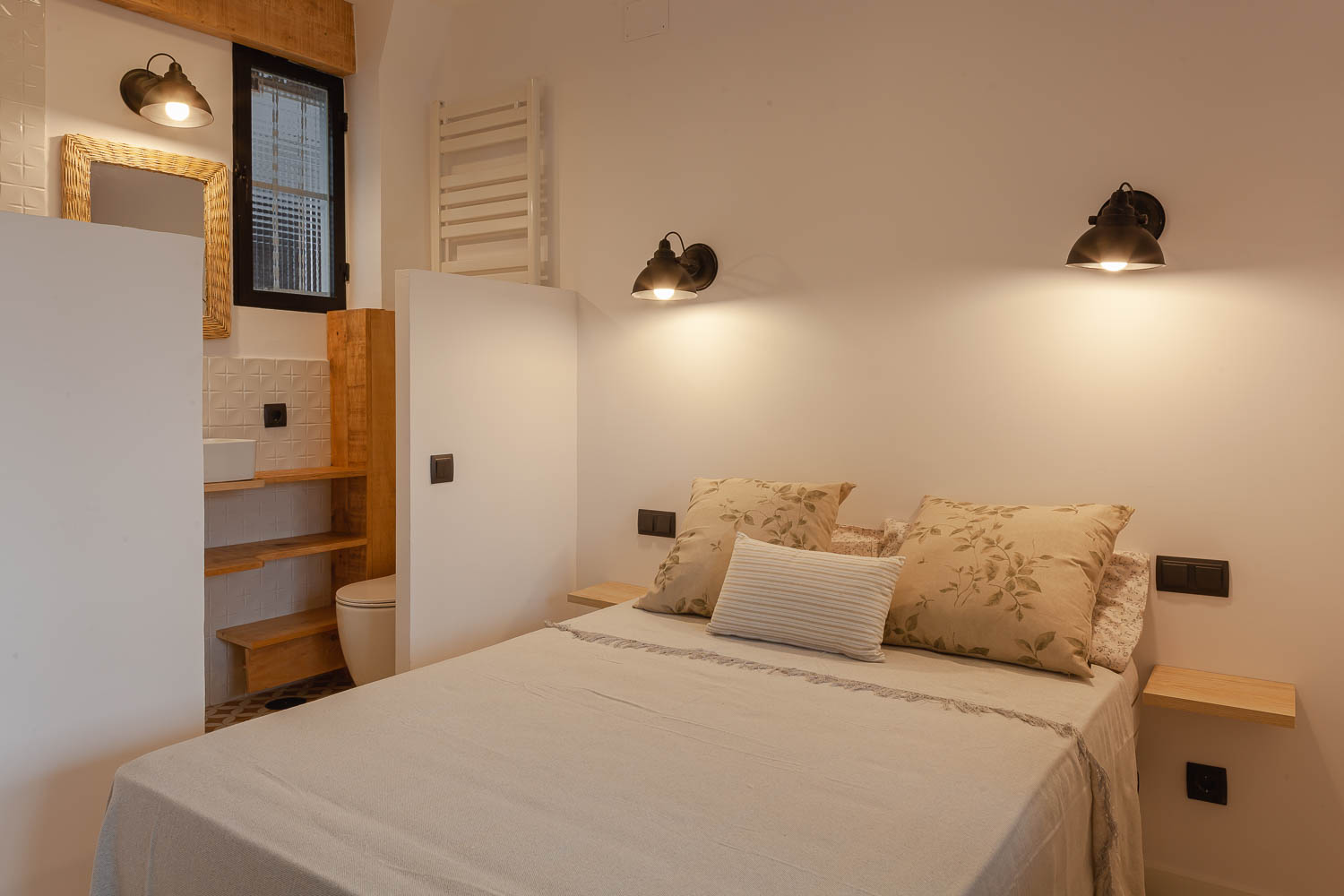 Dormitorio con baño integrado en mini piso en Madrid