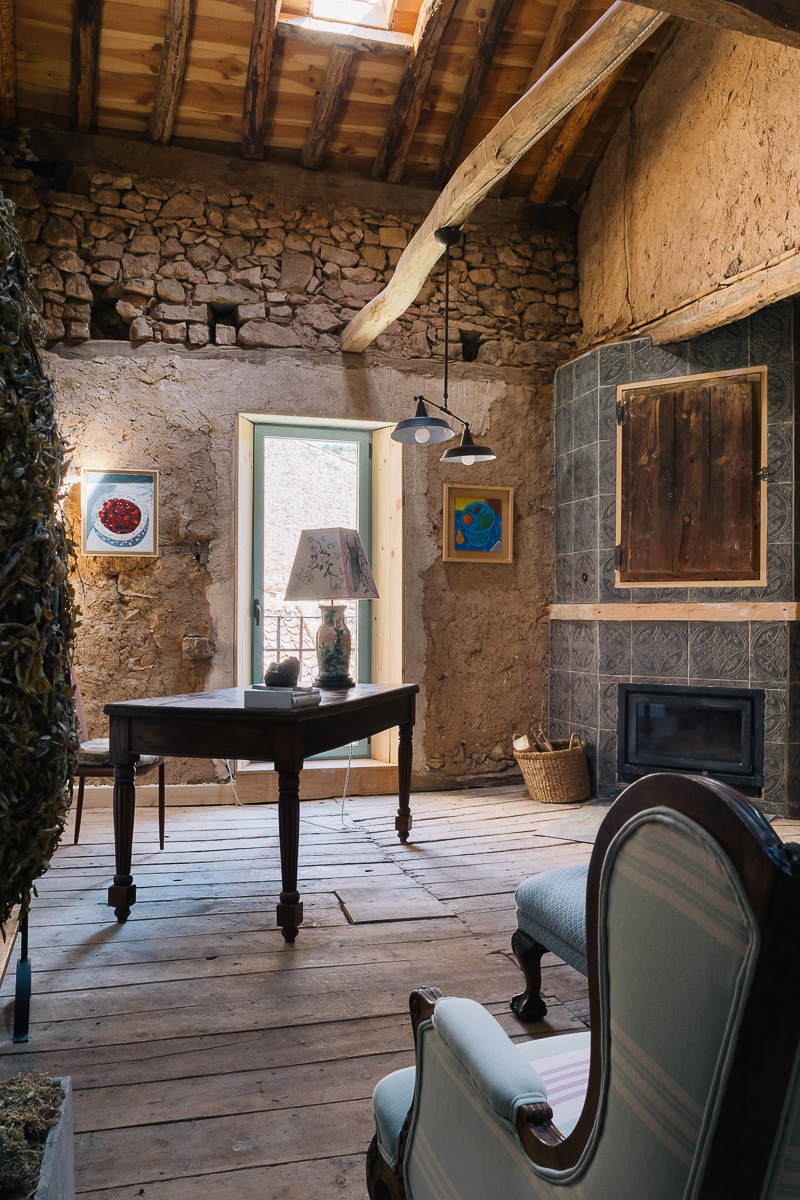 Detalle escultura casa rural. Salón rústico con muebles de madera, sofás cómodos y arte colorido en las paredes. Ambiente cálido y ecléctico
