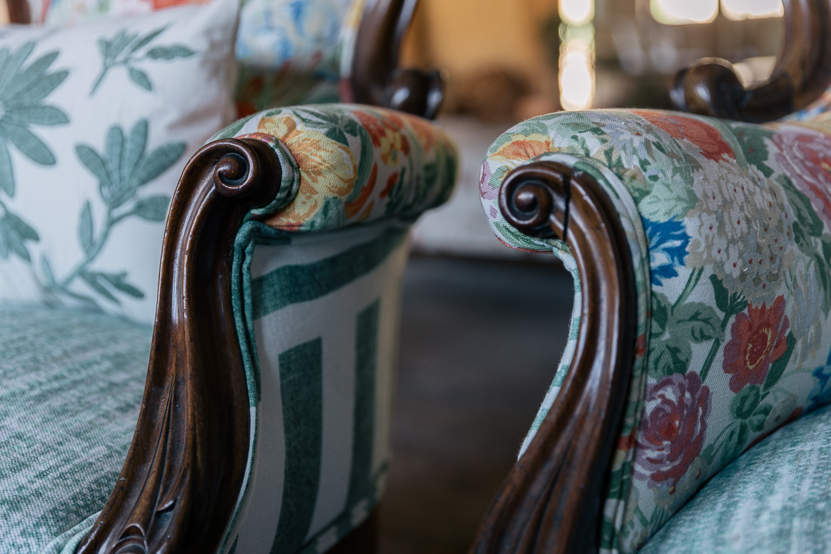 Detalle de sillones rehabilitados por Berta Mendoza con tapicería con motivos florales que se integran dentro de un salón que combina lo vintage con lo rural creando un estilo colorido, artístico y acogedor.