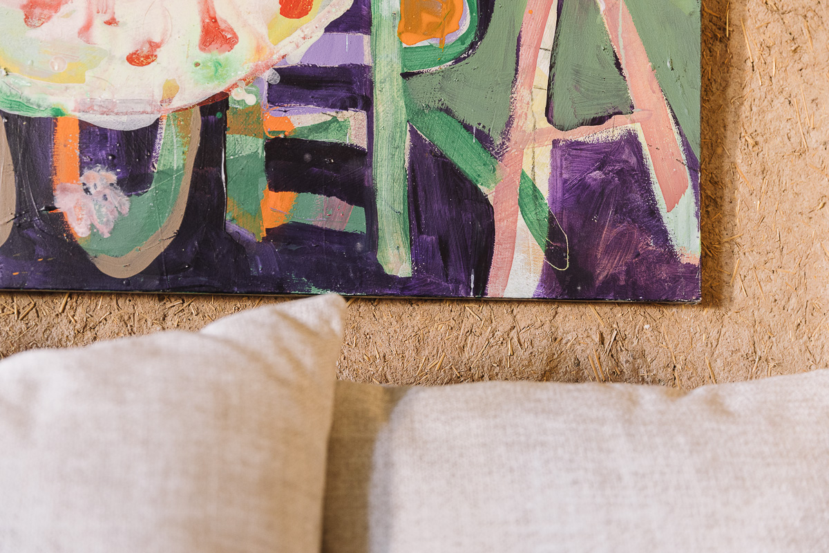 Detalle de lienzo de estilo con colores alegres. Obras de arte. Detalle de sillones rehabilitados por Berta Mendoza con tapicería con motivos florales que se integran dentro de un salón que combina lo vintage con lo rural creando un estilo colorido, artístico y acogedor.