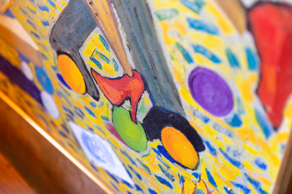 Detalle de lienzo de estilo con colores alegres. Obras de arte. Detalle de sillones rehabilitados por Berta Mendoza con tapicería con motivos florales que se integran dentro de un salón que combina lo vintage con lo rural creando un estilo colorido, artístico y acogedor.