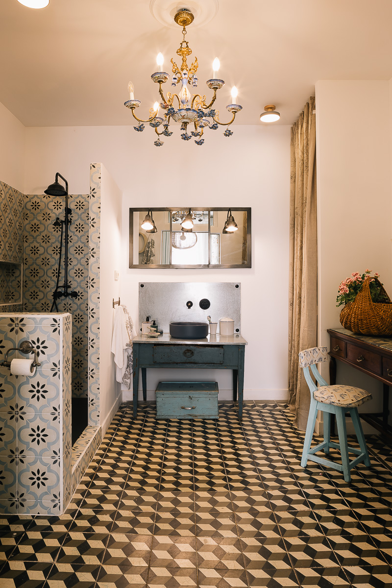 Baño con ducha en casa rural con detalles rúticos y antiguos.