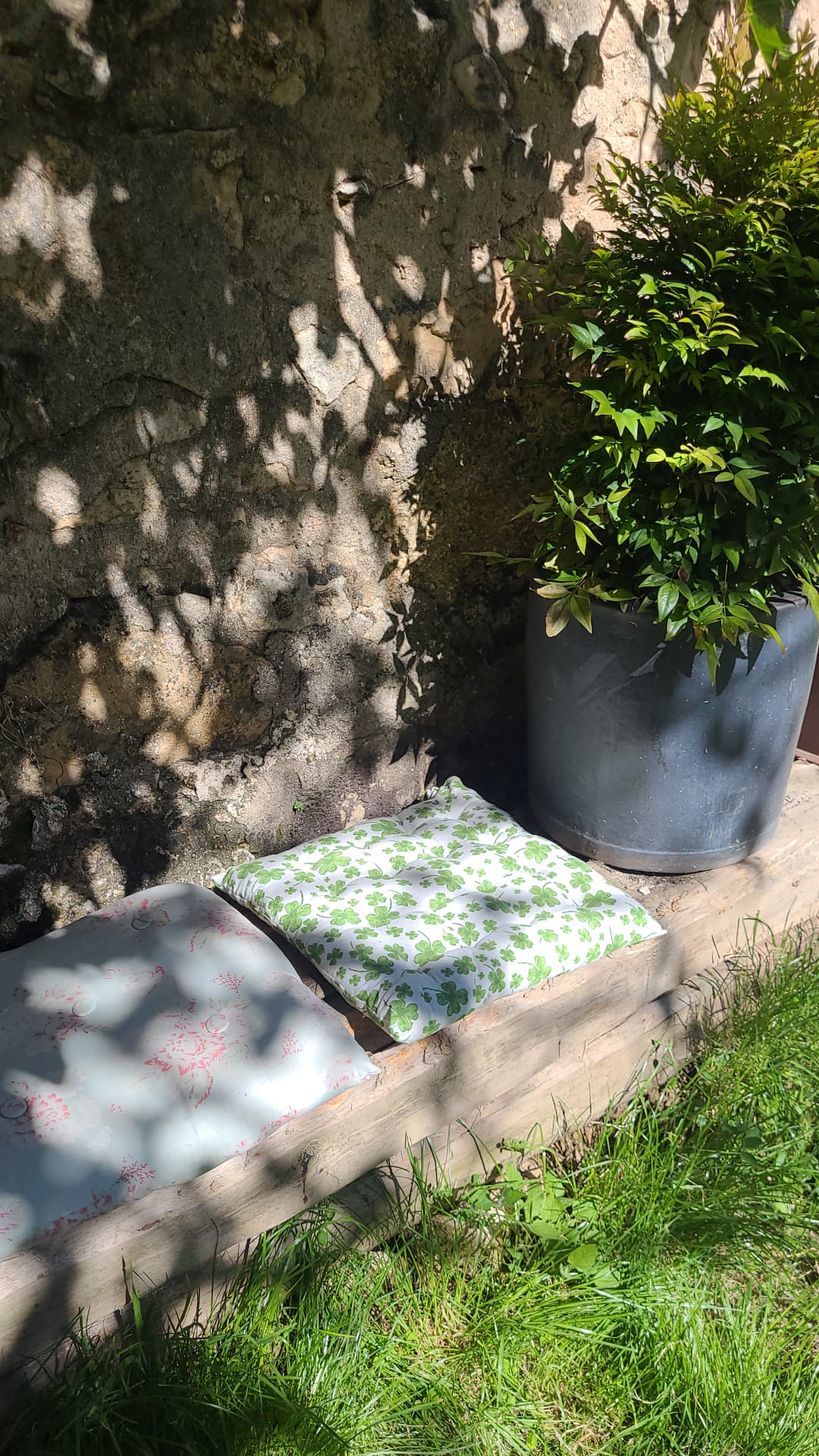 Jardín y asiento con cojines con estampado floral.